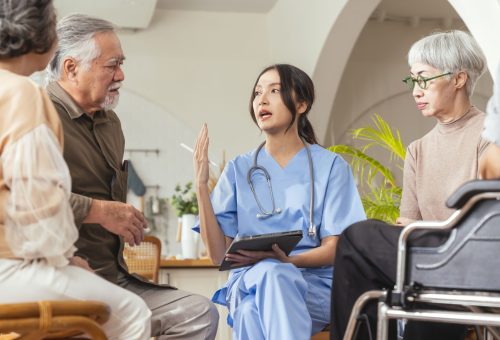 happiness-cheerful-elderly-woman-men-talking-with-female-caregiver-nurse-doctor-having-health-checking-consult-living-areacaretakers-with-senior-couple-sitting-living-room-nursing-home (1)